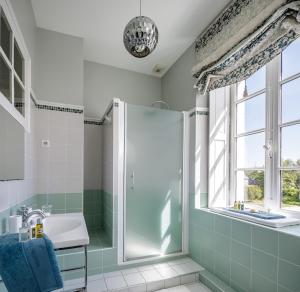 a bathroom with a shower and a sink and a window at Manoir de Bel Ébat in Crossac
