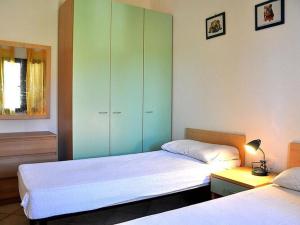 1 dormitorio con 2 camas y armario verde en Belvilla by OYO Casa Teodoro, en Loiri