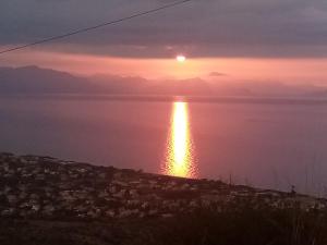 a sunset over a body of water with a city at Villa Verde in Cefalù