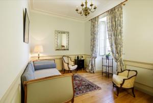 - une chambre avec un lit, deux chaises et un miroir dans l'établissement Manoir de Bel Ébat, à Crossac
