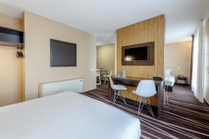 een hotelkamer met een bed en een bureau bij Zenitude Hôtel-Résidences Bordeaux Bègles in Bègles
