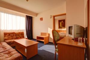 a hotel room with a couch and a tv at Central Plaza Hotel in Sofia