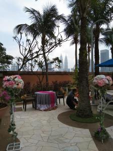 a man sitting next to a table with palm trees at Times Square Service Residents, Kuala Lumpur in Kuala Lumpur