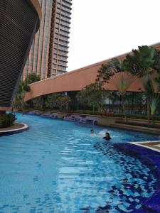 two people swimming in a swimming pool in a building at Times Square Service Residents, Kuala Lumpur in Kuala Lumpur