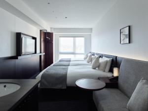 a hotel room with a large bed and a sink at Mitsui Garden Hotel Kyoto Kawaramachi Jokyoji in Kyoto