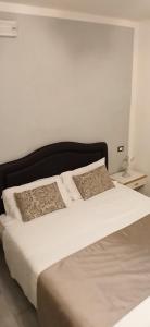 a bed with two pillows on it in a bedroom at Hotel Leonardo in Pisa
