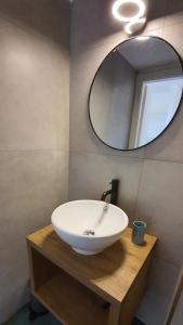 Un baño con un lavabo blanco y un espejo. en Casale 7- Navigli Cozy Studio perfect x2!, en Milán