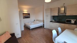 a room with a kitchen with a bed and a microwave at Casale 7- Navigli Cozy Studio x2! Self Check-In in Milan