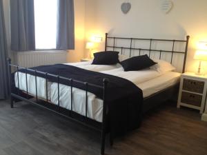 
a bed with white sheets and pillows in a room at Bed & Breakfast Villa Elisabeth in Domburg
