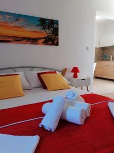 a bedroom with a large bed with a red rug at Apartments Dario in Pag