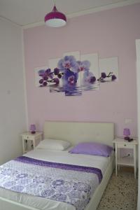 1 dormitorio con 1 cama y 2 mesas con almohadas moradas en Sorrento Experience, en Sorrento