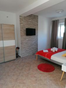 a bedroom with a large bed and a brick wall at Apartments Dario in Pag