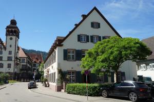 a large white building with a clock tower on a street at Hotel Gasthaus Schützen in Freiburg im Breisgau