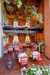 un restaurante con mesas, sillas rojas y flores en Paladino, en Sciolze
