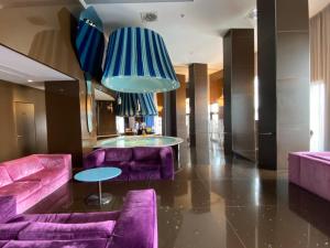 eine Lobby mit lila Sofas und einem blauen Kronleuchter in der Unterkunft JR Hotels Bari Grande Albergo delle Nazioni in Bari