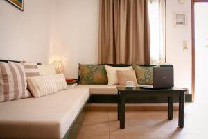 a living room with a couch and a laptop on a table at Villa Vicky in Hersonissos +33 photos