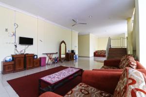 a living room with a couch and a tv at Surya Homestay Pekanbaru in Pekanbaru