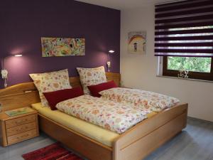 sypialnia z drewnianym łóżkiem i oknem w obiekcie Ferienwohnung Bienenherz w mieście Engelsbrand
