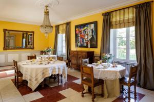 a dining room with two tables and yellow walls at Manoir de Bel Ébat in Crossac