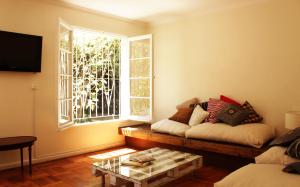 sala de estar con sofá y ventana en Casa Familiar, en Santiago