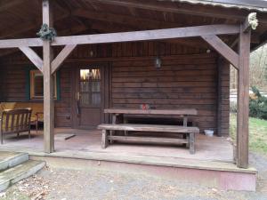 a wooden cabin with a picnic table and a bench at Ferienhaus Waldhütte Ferch in Schwielowsee