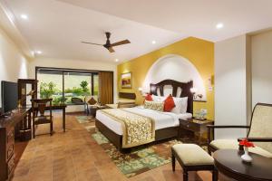 a hotel room with a bed and a desk at Aloha On The Ganges by Leisure Hotels in Rishīkesh