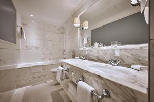 a bathroom with a sink and a large mirror at Victoria Jungfrau Grand Hotel & Spa in Interlaken