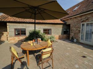 a wooden table with an umbrella on a patio at BB House in Bedford