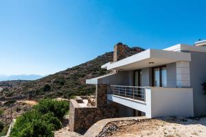 a house on the side of a mountain at Athina Stunning Elounda View Apartment in Elounda