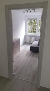 um quarto com um espelho, uma cama e uma janela em Mieszkanie 2 pokojowe Pomorzany em Szczecin