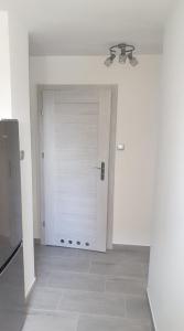 a room with a white door and a ceiling fan at Mieszkanie 2 pokojowe Pomorzany in Szczecin