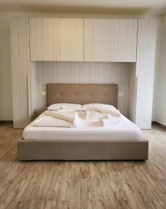 a bed with white sheets and pillows in a bedroom at Giuchry Apartment in Merano