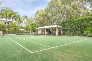 a tennis court in front of a house at Mandalay Luxury Beachfront Apartments in Port Douglas