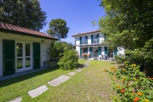 una casa con puertas verdes y un patio con flores en Villa Victor 100m from sea - Happy Rentals, en Marina di Massa