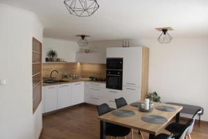 a kitchen and dining room with a table and chairs at Apartmán Domčeková in Košice