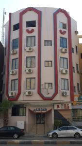 a large building with two floors and a car parked in front at Canary Hotel in Hurghada