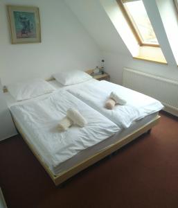 ein großes weißes Bett mit zwei Kissen darauf in der Unterkunft Penzion pivovarská restaurace Moravia in Brünn