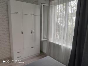 um quarto com armários brancos e uma janela em ,,salomea,, em Tbilisi
