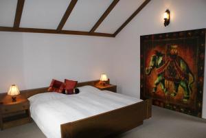 1 dormitorio con 1 cama con una pintura en la pared en Haasenhaus, en Hinterstoder