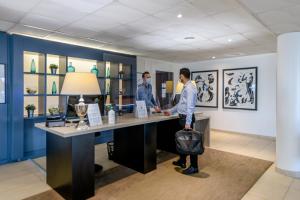 2 hommes debout sur un bureau dans une pièce dans l'établissement Zenitude Hôtel-Résidences Bordeaux Bègles, à Bègles