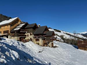 a ski lodge on top of a snow covered slope at Chalet Lucie LE CHEVAL NOIR in Valmorel