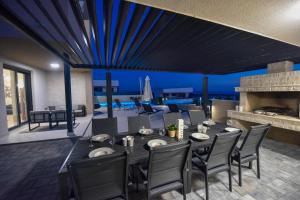 uma sala de jantar com uma mesa e cadeiras e uma lareira em Villa Sara - Private Infinity Pool em Novalja