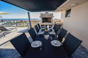 a table with chairs and plates on a patio at Villa Sara - Private Infinity Pool in Novalja