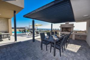 a patio with a table and chairs and a fireplace at Villa Sara - Private Infinity Pool in Novalja