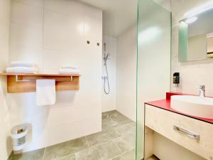 un bagno con lavandino e doccia di I AM HOTEL Graz-Seiersberg a Graz