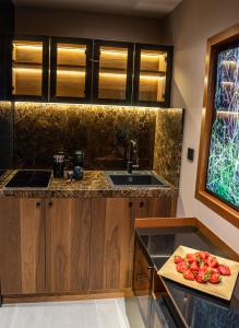 a kitchen with a sink and a counter with tomatoes on a cutting board at Marconio Wellness Private Pool & SPA - City Center in Belgrade