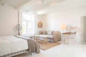 ein Schlafzimmer mit einem Bett, einer Couch und einem Tisch in der Unterkunft Luttik in Alkmaar