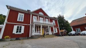 a red house with a yellow door on a street at Kolbäcks Gästgivaregård in Kolbäck