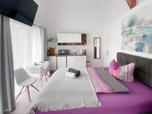 a bedroom with a large bed with a purple rug at Schwanenburg Apartments in Panketal