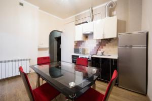 a kitchen with a black table and red chairs at Apartment on Virmenska 3, with 2 separate bedrooms in Lviv